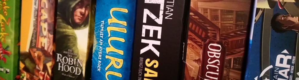 Aufgereihte Brettspiele im Regal